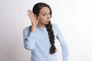 Woman cupping a hand to her ear