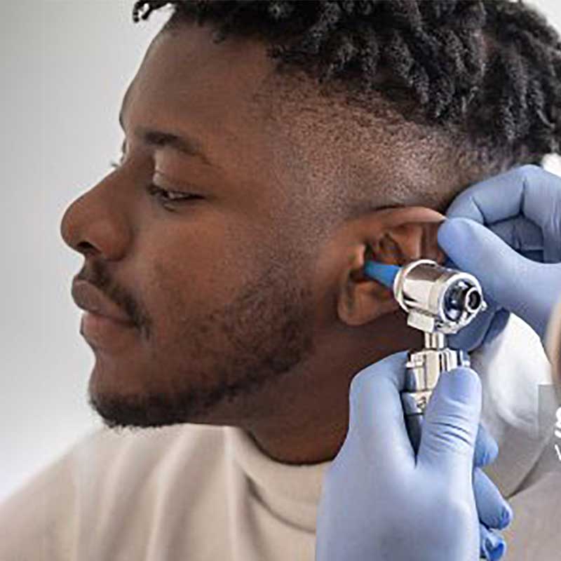 Man getting his ear checked by a doctor