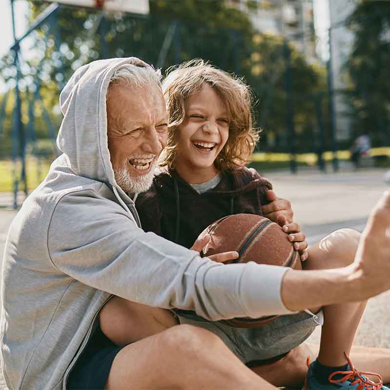 Grandfather and grandson taking a selfie after playing basketbal