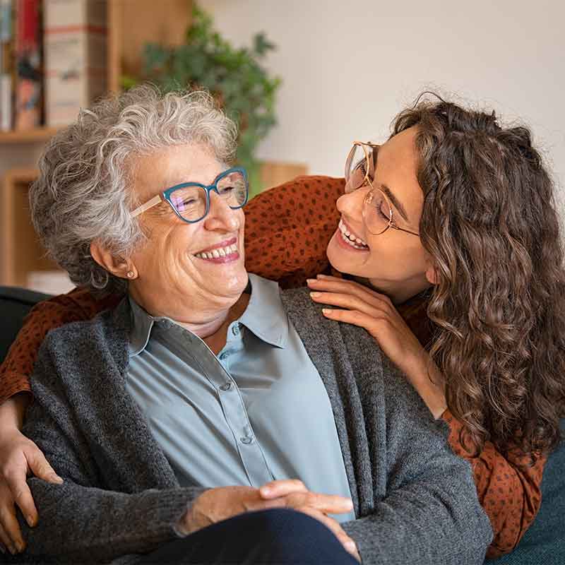 Grandmother and granddaughter smiling at each other